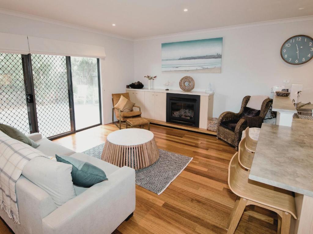 a living room with a white couch and a fireplace at Flinders Rest in Queenscliff