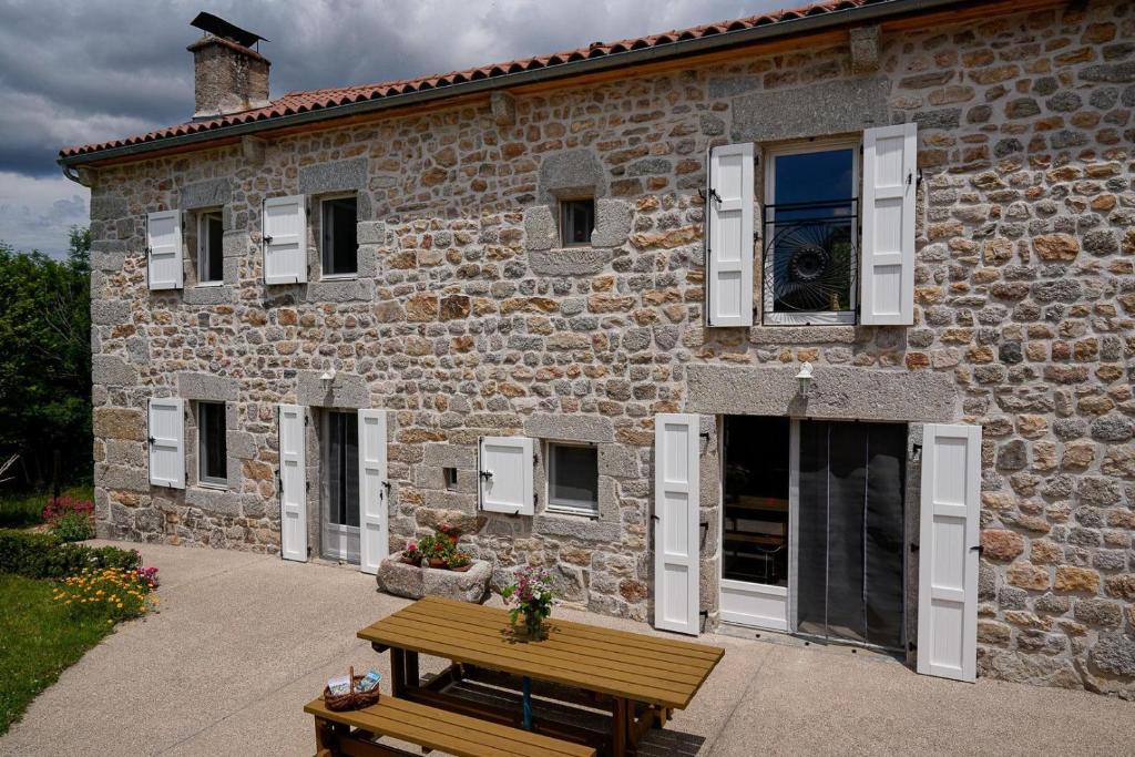 a stone building with a wooden bench in front of it at La maison de clémence 6 personnes in Mialanes