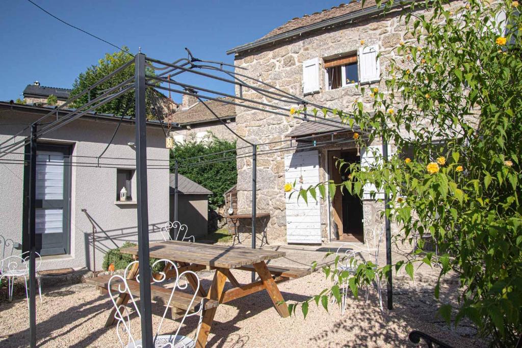 a wooden picnic table in front of a building at L'echappée de la lozère in Les Laubies
