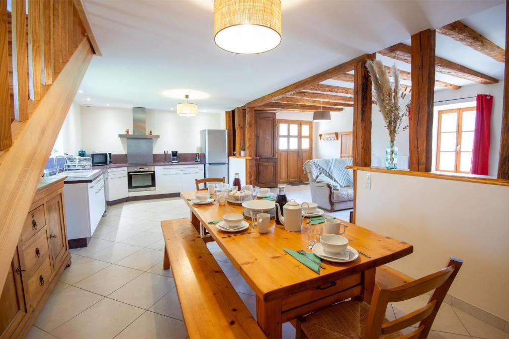 a kitchen and dining room with a wooden table at Gîte du boy 8 personnes in Lanuéjols