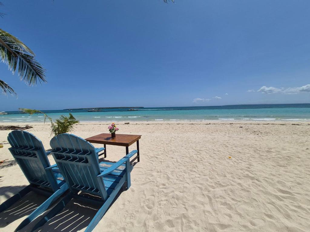 two chairs and a table on the beach at Chef Panyang Beach Resort Okoy in Ocoy