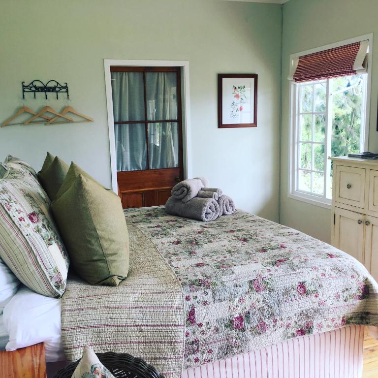 a bedroom with a bed and a window at Cheverells Farm, Kiku & Braeburn Cottage in Grabouw