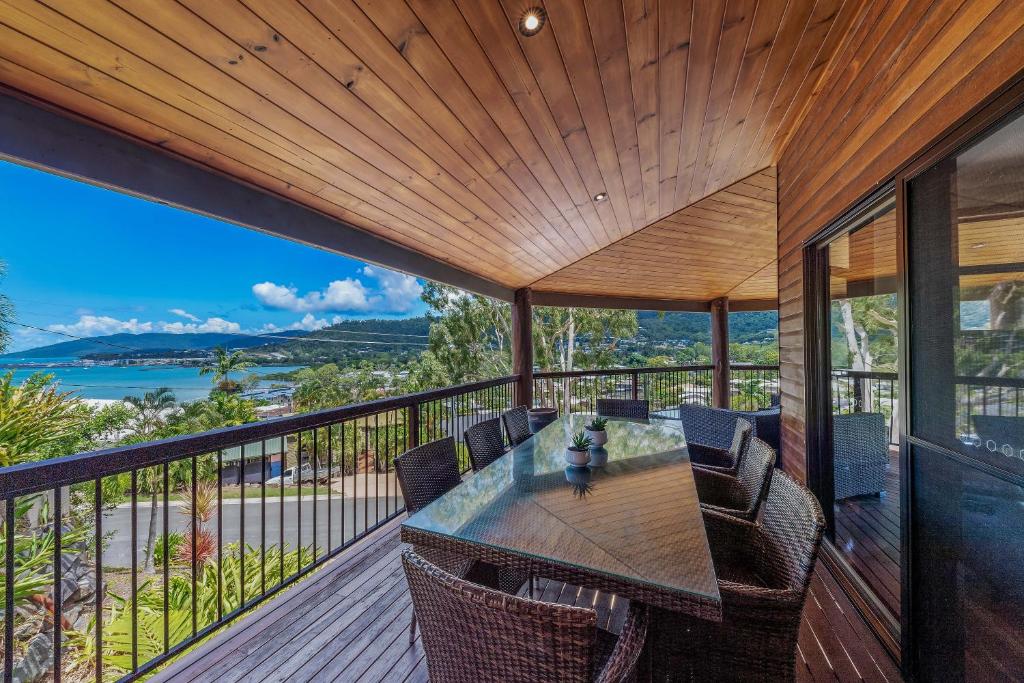 an open deck with a table and chairs on a balcony at Seascape Paradise in Airlie Beach
