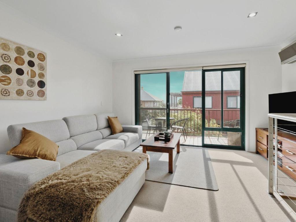a living room with a couch and a table at Marley s Place in Queenscliff