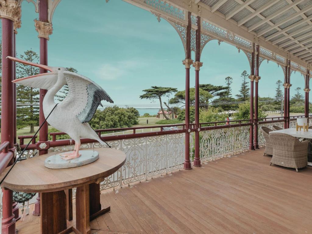 a statue of a bird sitting on a table on a balcony at Pelicans at the Ozone in Queenscliff