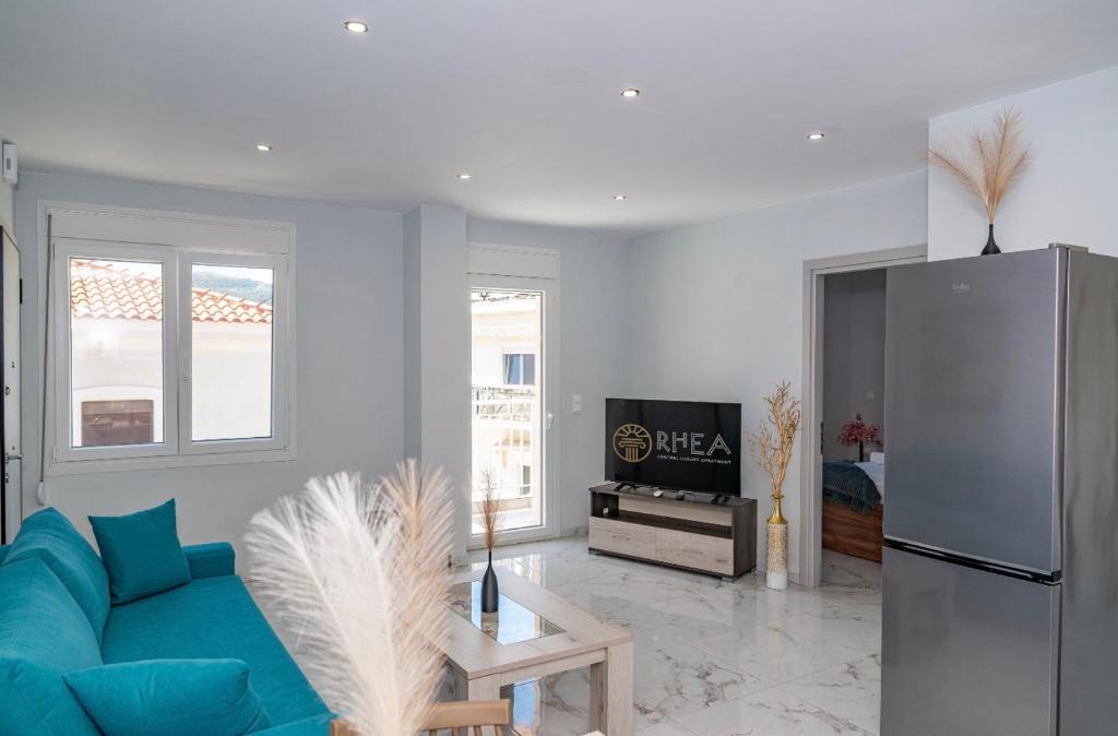 a living room with a blue couch and a refrigerator at Rhea Central Luxury Apartment in Samos