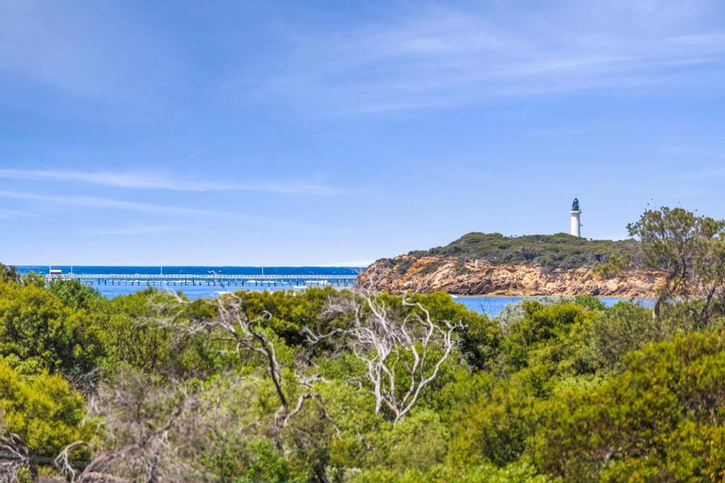 a cross on top of a hill with water and trees at The Beach House in Point Lonsdale