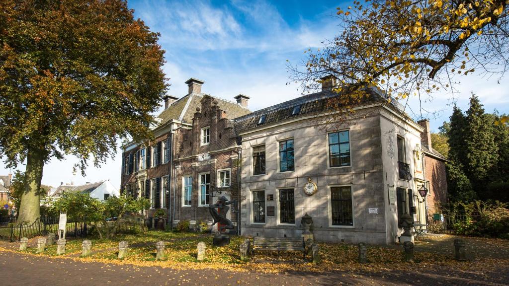 Ein altes Haus mit einem Mann, der davor steht. in der Unterkunft Logement Swaenenvecht in Utrecht