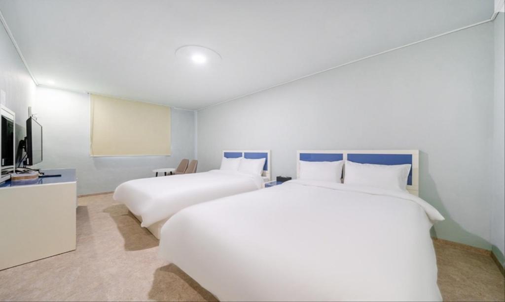 a hotel room with two beds and a flat screen tv at Taean Manripo Feel Hotel in Taean