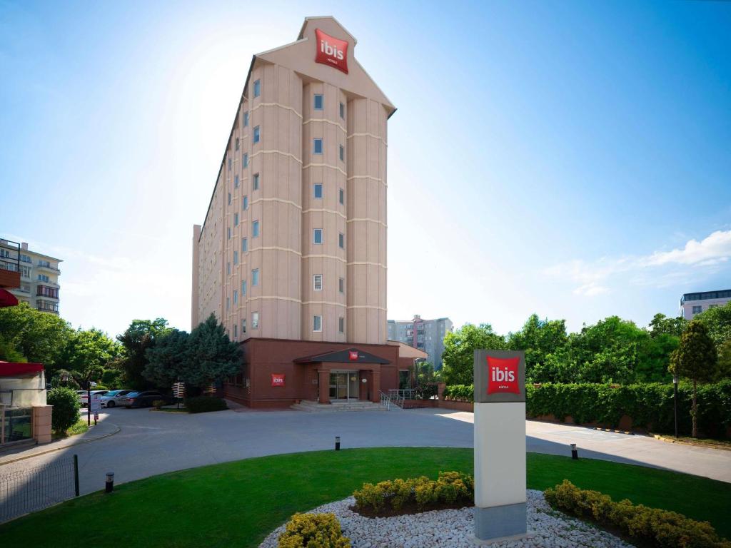 a tall building with a sign in front of it at Ibis Eskisehir in Eskisehir
