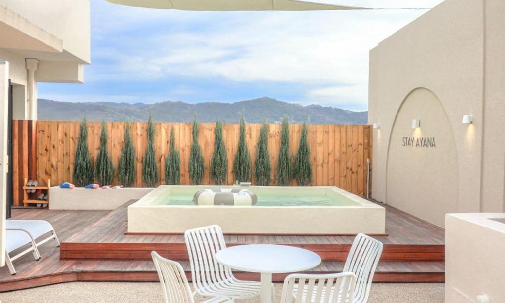 a patio with a hot tub and chairs and a fence at HOTEL STAY AYANA DAEJEON in Daejeon