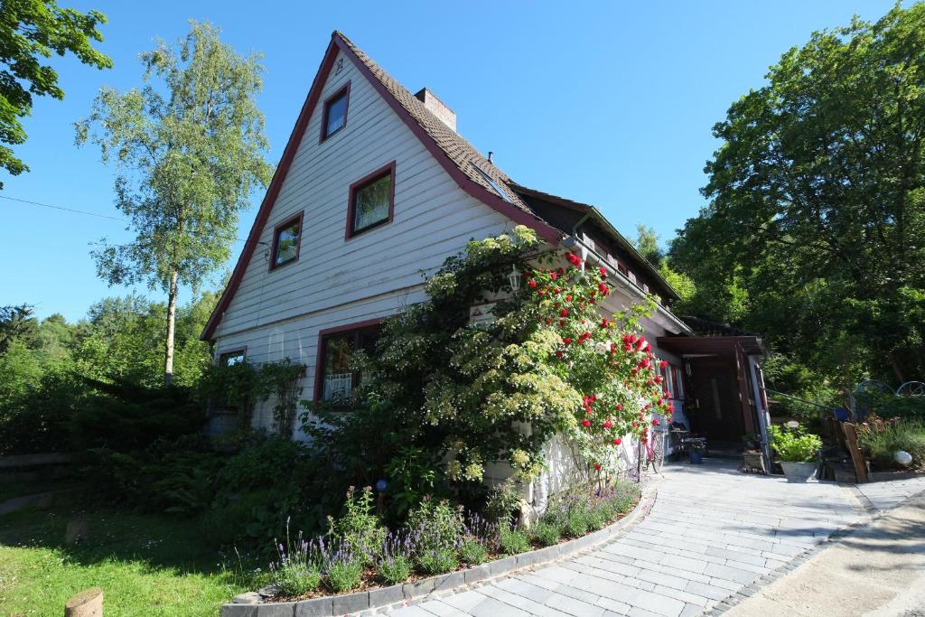 a white house with flowers on the side of it at Frauenpension Arleta - Women only in Goslar