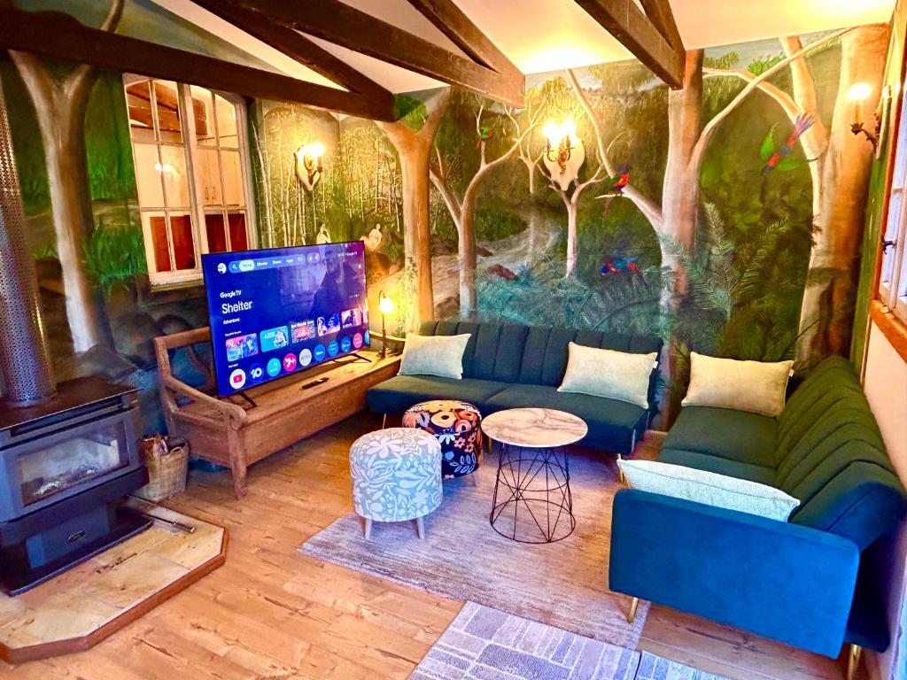a living room with a couch and a tv at 2 bedroom Guesthouse in the Centre of Noojee in Noojee