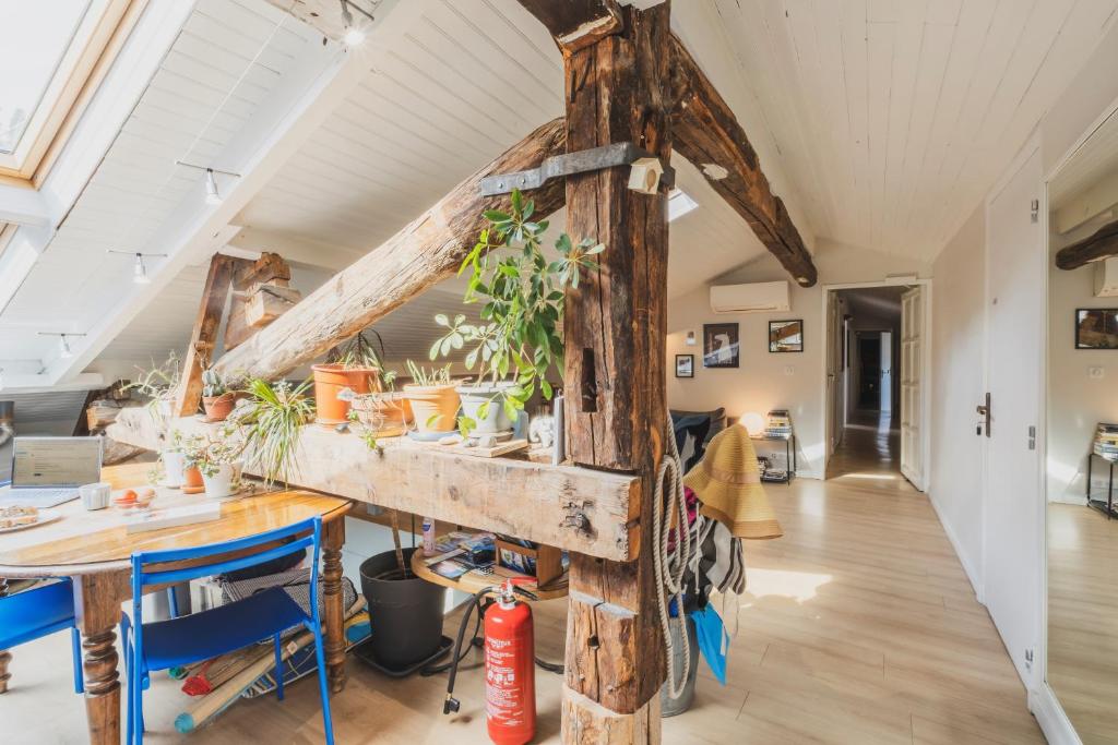 a room with a table and a wooden pole at La Mansarde du Port FAMILLY HOME in Nice