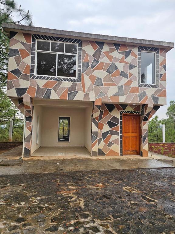 a house with a mosaic facade at CABAÑAS SANAMBO fraccionamiento los gallos in Balastre Rojo