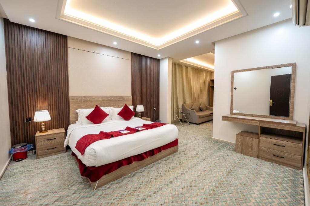 a hotel room with a large bed and a television at راحتي هنا للشقق المخدومة 7 in Riyadh