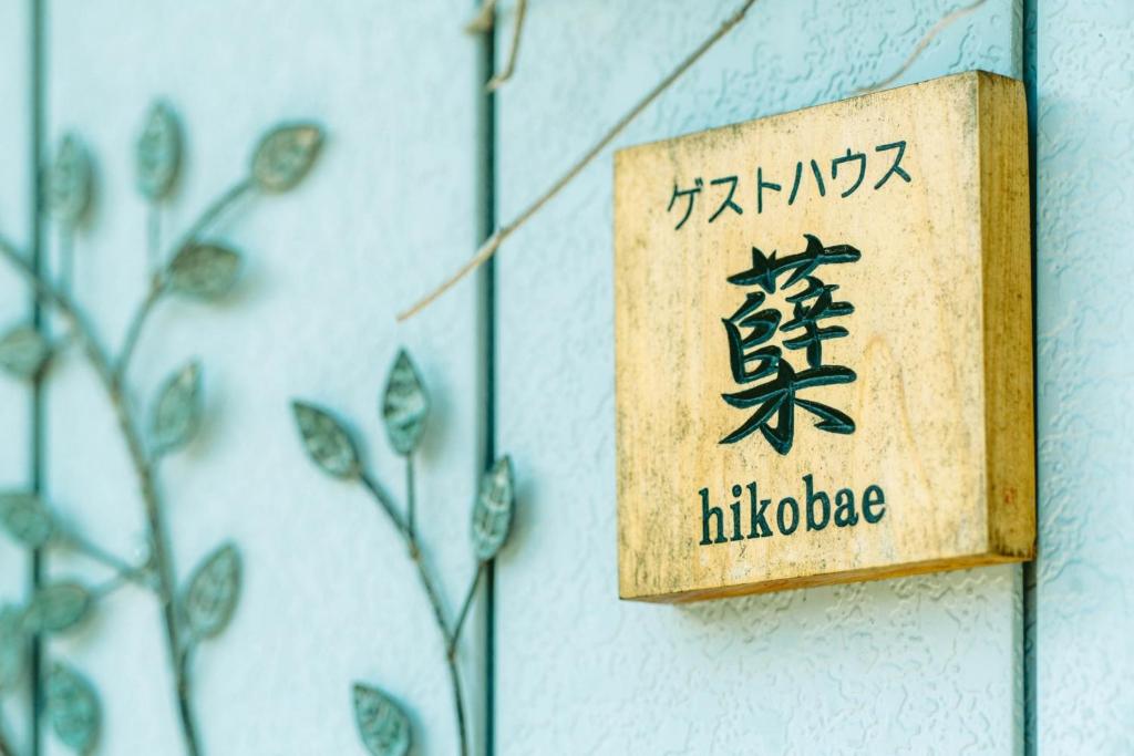 a sign on the side of a wall with plants at ゲストハウス蘖 -ひこばえ in Kitakami