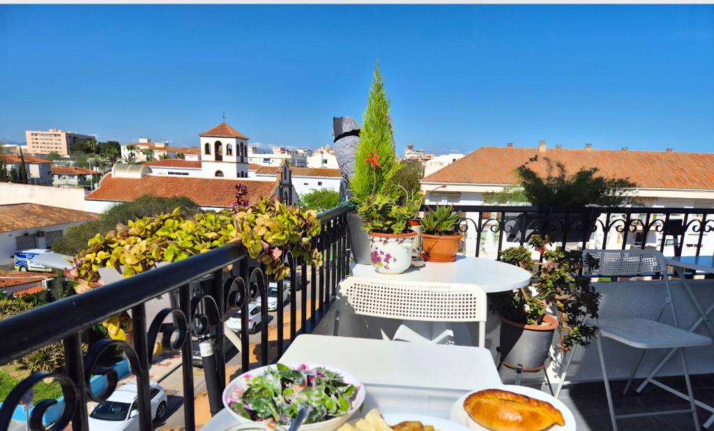 a balcony with tables and plants on a roof at Habitaciones Torremolinos in Torremolinos