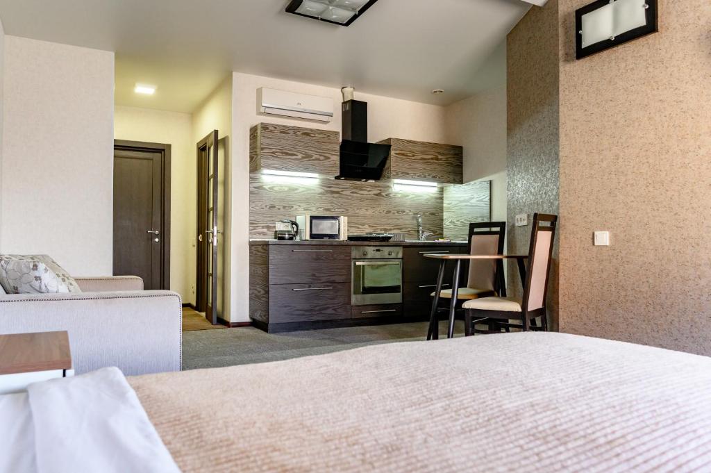 a hotel room with a bed and a kitchen at Grecheskaya Central Suites in Odesa