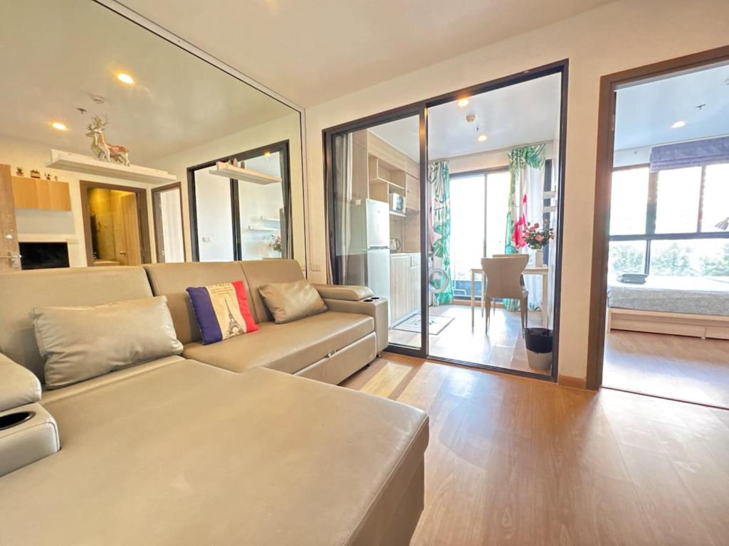 a living room with a couch and a table at Sanphawut IDEO CONDO in Bang Chak