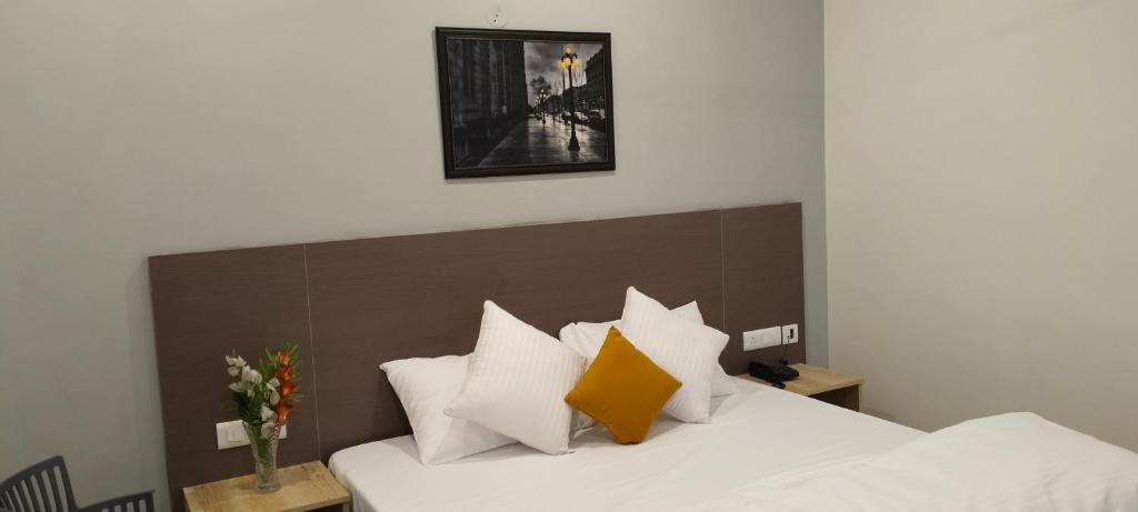 a bedroom with a bed with white and orange pillows at Starry Hills Resort in Dwārīkhāl