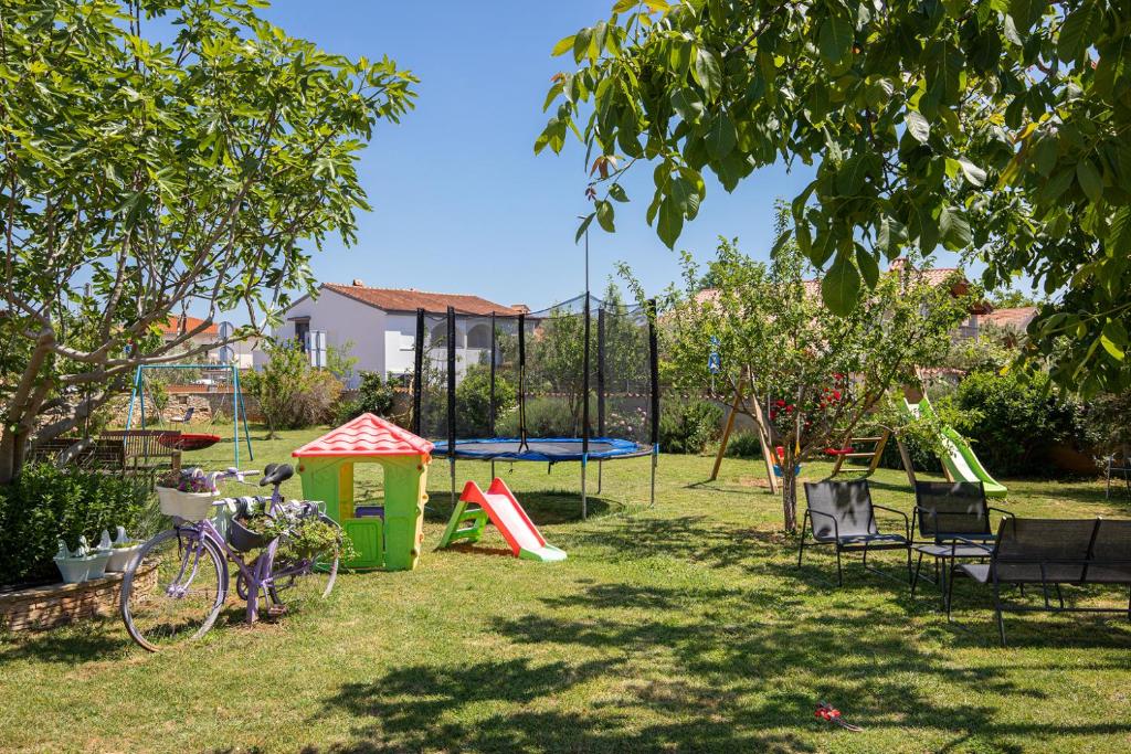 a park with a playground with a trampoline at Apartments Dadic with parking & playground in Medulin