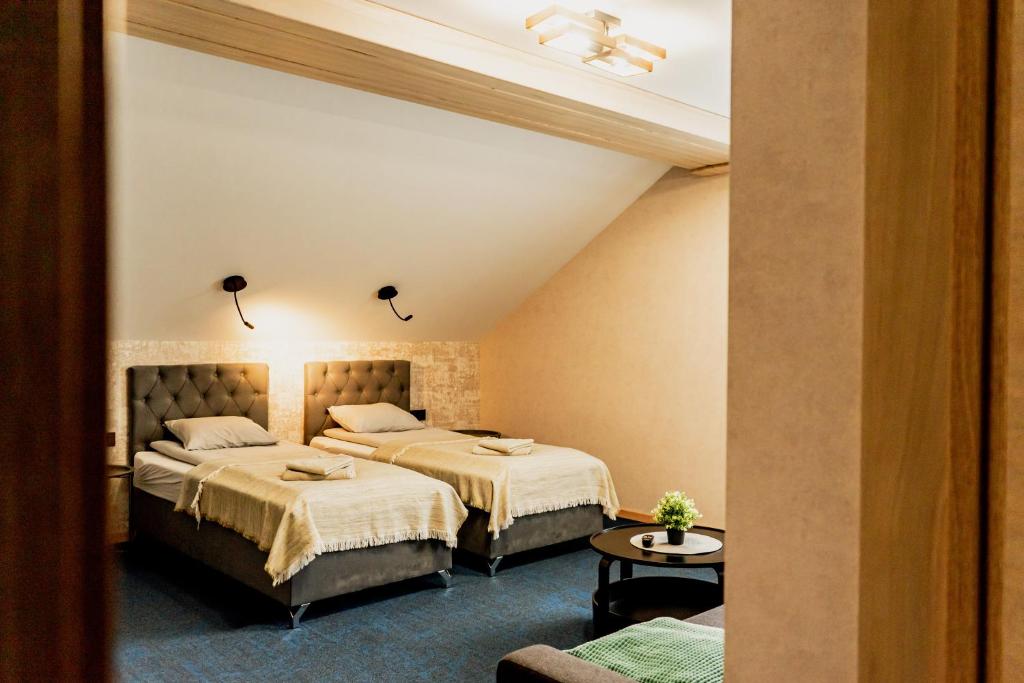 a hotel room with two beds and a couch at Naktsmītne - Fišers in Viesīte