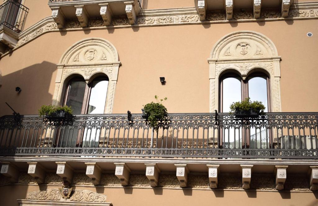 un balcone con piante in vaso su un edificio di Cento Tari' Guest House a Castiglione di Sicilia