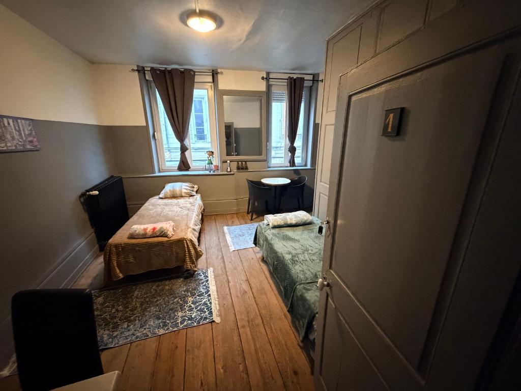 a small room with two beds and a door at Gengoult 1 in Toul