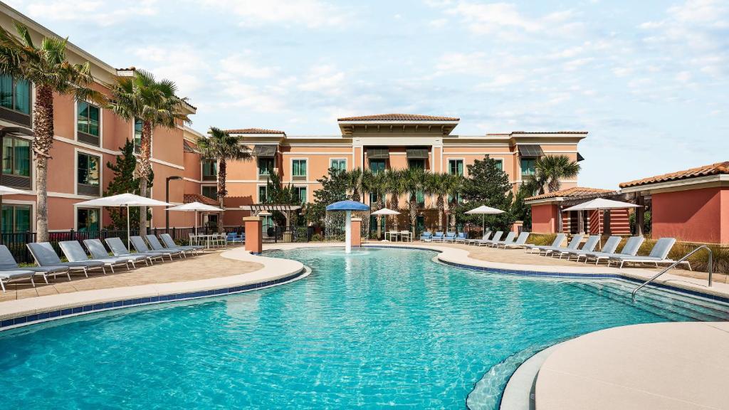a pool with chairs and umbrellas in a hotel at Hampton Inn & Suites Destin in Destin