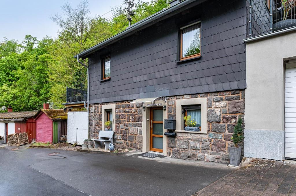 a stone house with a red garage at Ferienhaus Mayer in Idar-Oberstein