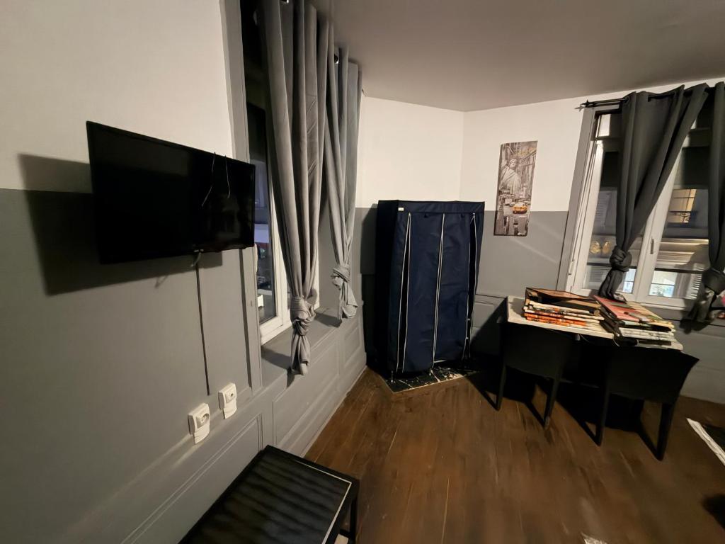 a living room with a flat screen tv and a desk at Gengoult 2 in Toul