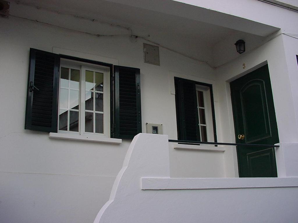 una casa bianca con porte verdi e una finestra di Cozy House a Lagos