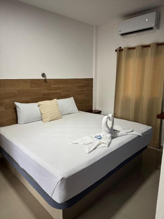 a bedroom with a bed with a towel on it at Posada El Pejelagarto in Bacalar