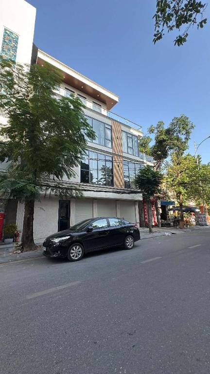 a black car parked in front of a building at Nâu Homestay in Hai Phong