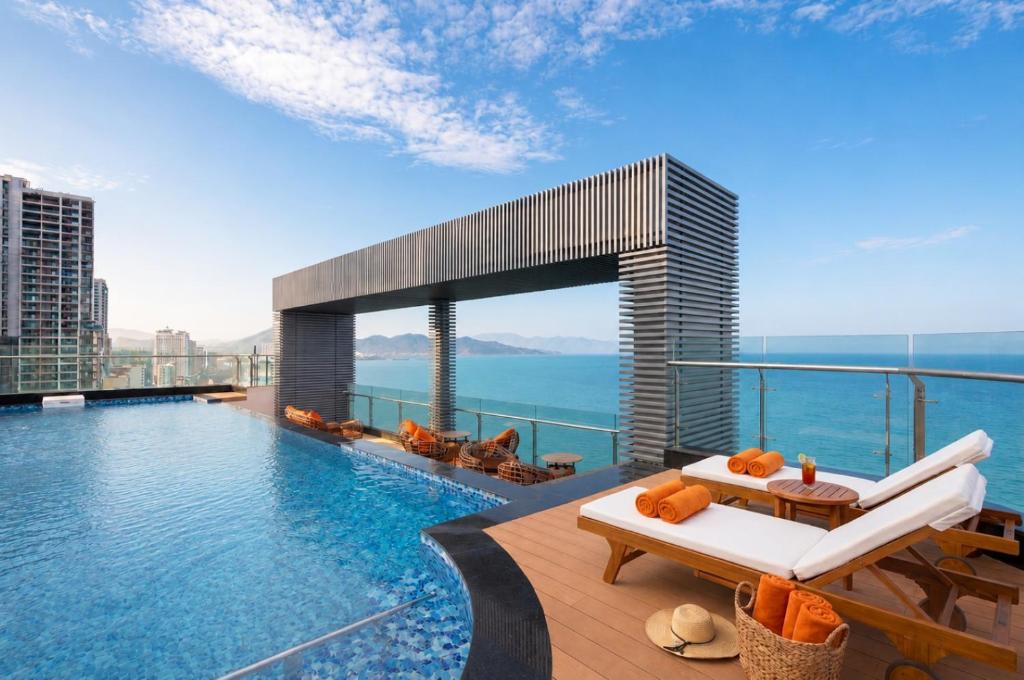 a pool on the top of a building with a view at Comodo Nha Trang Hotel in Nha Trang