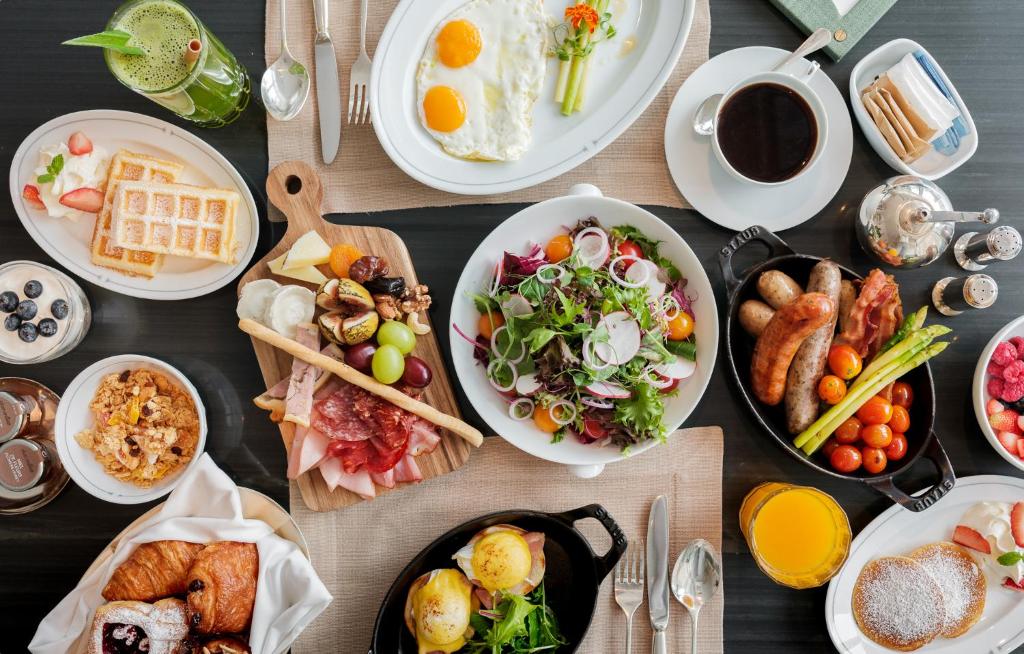 A generously styled breakfast spread with hot dishes, fruit, pastries, and coffee.