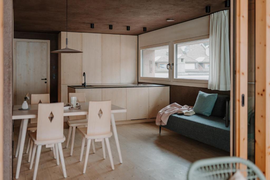 a kitchen with a table and chairs and a couch at ATTO Apartments in San Candido