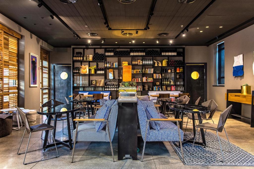 a restaurant with tables and chairs and a bar at Bezalel Hotel - an Atlas Boutique Hotel in Jerusalem
