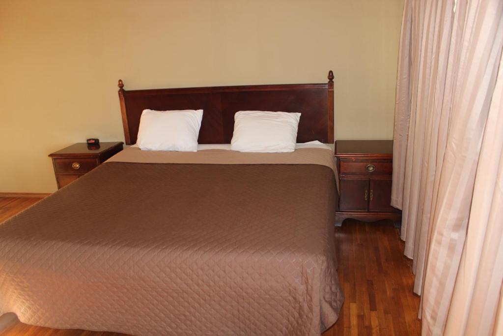 ein Schlafzimmer mit einem großen Bett mit zwei Kissen in der Unterkunft Eastwood Inn of Wadena in Wadena