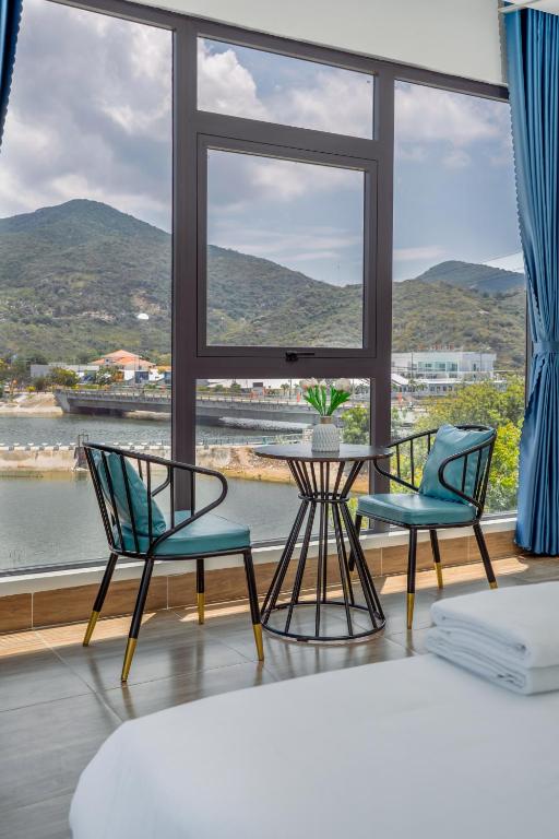 a room with two chairs and a table and a window at Vinh Hy Horizon in Vĩnh Hy