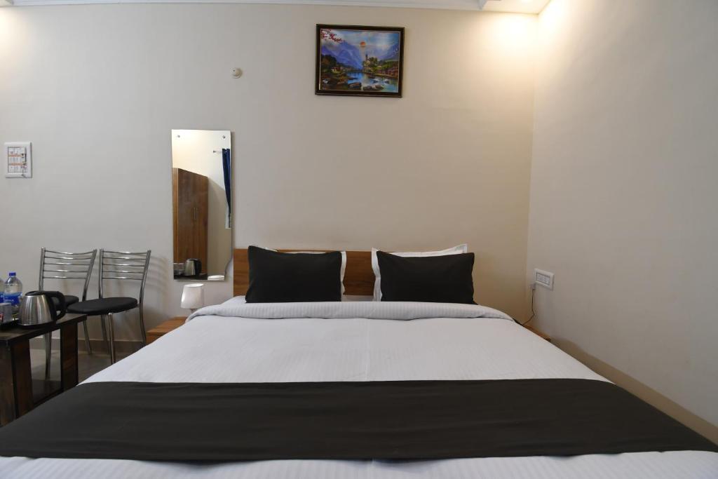 a bedroom with a large white bed with black pillows at Hotel Sonnet Inns in Rānchī