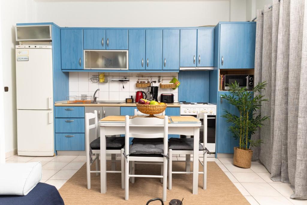 a kitchen with blue cabinets and a table with chairs at Touzla Blue Heaven in Orfánion