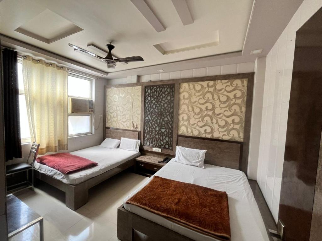 a bedroom with two beds and a couch at Hotel Haji Ali - Sahil inn in Ajmer