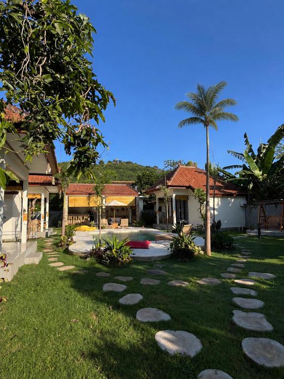a garden with stepping stones in front of a house at Di rumah Vima homestay in Pemuteran