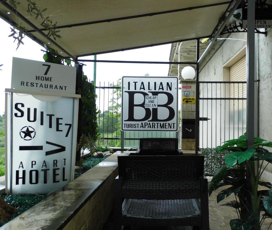a sign for a hotel with a bench in front at Suite seven &Home Restaurant in Paglieta