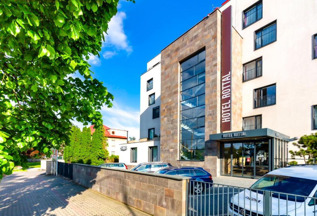 a building with cars parked in front of it at Hotel Rottal in Otrokovice