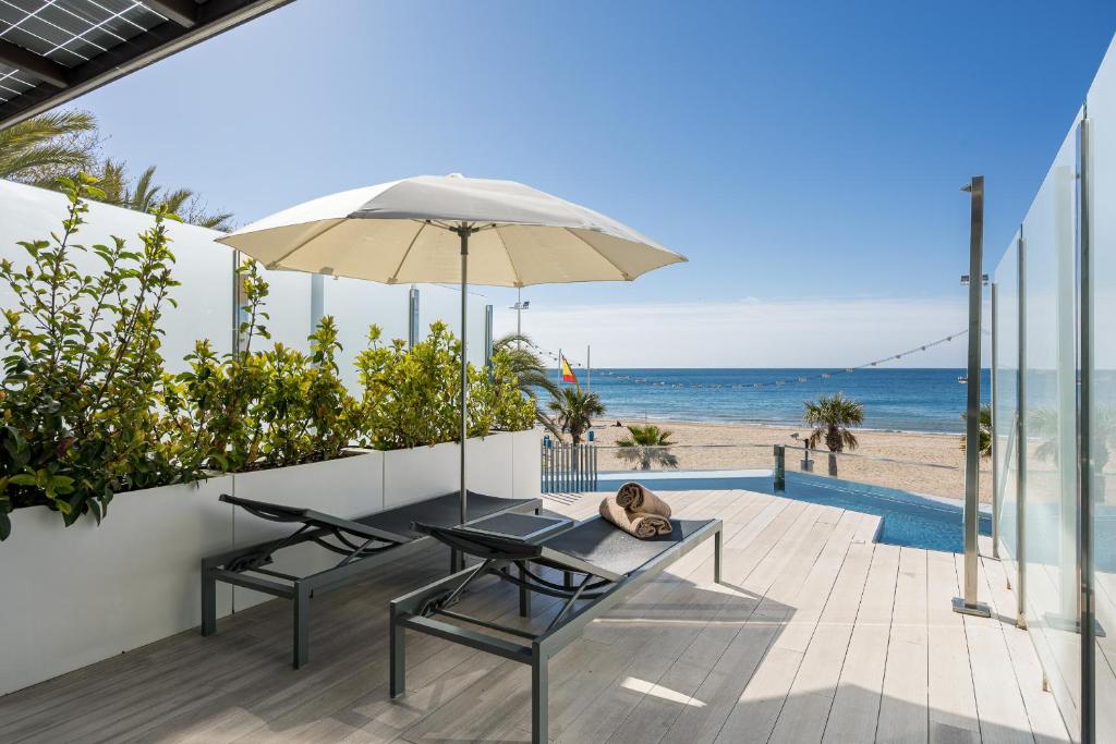 a patio with a table and an umbrella and the beach at Hotel Cimbel in Benidorm