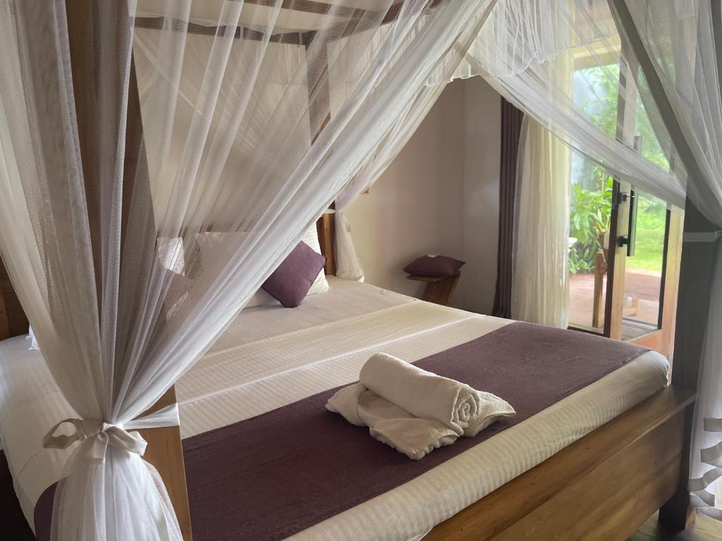 a bedroom with a canopy bed with white curtains at Villa Flamingo in Ahangama