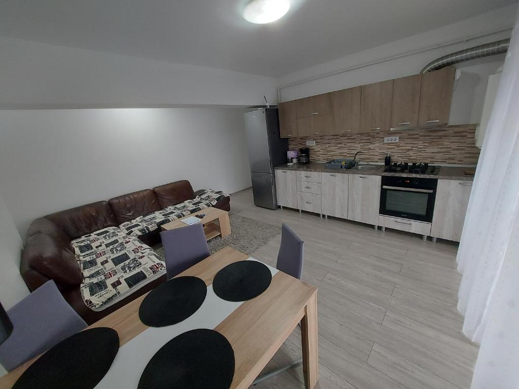 a living room with a couch and a table and chairs at Apartament Dem Radulescu Bloc nou! in Râmnicu Vâlcea